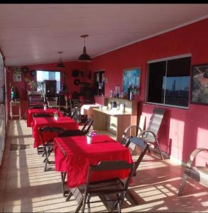 a restaurant with red tables and chairs in a room at Hotel Pousada na Br 040 in Valparaíso de Goiás