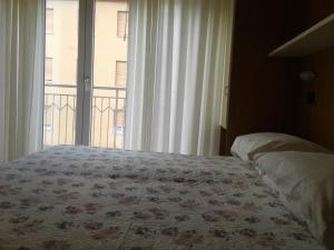 ein Schlafzimmer mit einem Bett und einem großen Fenster in der Unterkunft Albergo Moderna in Tabiano