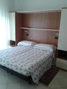 Schlafzimmer mit einem großen Bett mit einem Kopfteil aus Holz in der Unterkunft Albergo Moderna in Tabiano