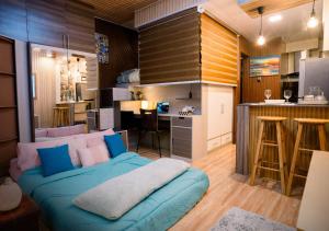 a living room with a blue couch and a kitchen at G-Luxe Panabo Guesthouse - Unit A in Panabo