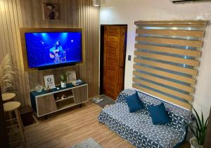 a living room with a couch and a flat screen tv at G-Luxe Panabo Guesthouse - Unit A in Panabo