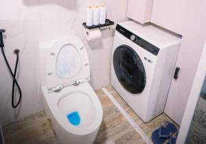 a bathroom with a toilet and a washing machine at G-Luxe Panabo Guesthouse - Unit A in Panabo