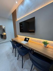 a conference room with a table and chairs and a tv at Apartamento a 50m da praia em Camocim CE in Camocim