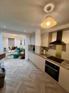 a kitchen and living room with a stove top oven at Ilayda Stays - 22 Alexandra Street in Port Talbot