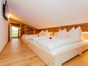 two white beds in a room with wooden floors at Das Rendlgut Top 4 in Lofer