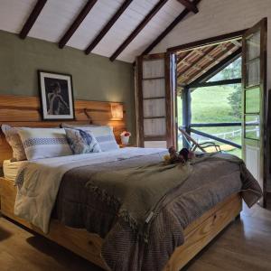 a bedroom with a large bed and a large window at Pousada Vale Monte Azul in Santo Antônio do Pinhal +224 photos