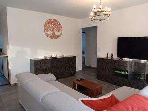 a living room with a couch and a flat screen tv at Maison individuelle 6 personnes in Coux