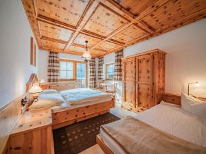 a bedroom with two beds and a wooden ceiling at Andre Top 2 in Wald im Pinzgau