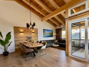 a dining room and living room with a wooden ceiling at Gipfelglück in Sankt Lambrecht