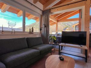 a living room with a couch and a flat screen tv at Gipfelglück in Sankt Lambrecht