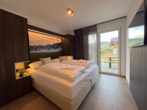 a bedroom with a large bed and a balcony at Gipfelglück in Sankt Lambrecht