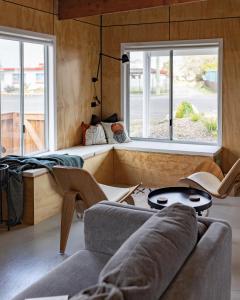 a living room with a couch and two windows at The Rectory Zeehan in Zeehan