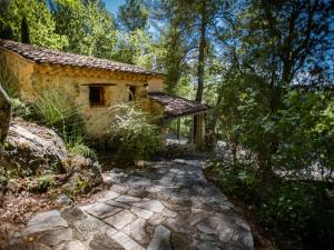 a stone walkway leading to a house in the woods at Orchidée in Barjols