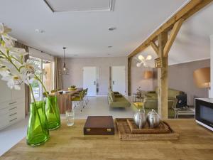 a living room with green glass vases on the floor at Design Farmers Barn Twente in Haaksbergen