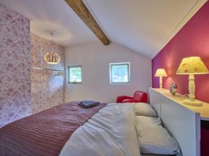 a bedroom with a bed and a red wall at Design Farmers Barn Twente in Haaksbergen