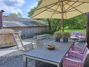 a table and chairs with an umbrella on a patio at Design Farmers Barn Twente in Haaksbergen