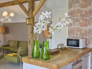 two green vases with white flowers on a counter at Design Farmers Barn Twente in Haaksbergen +22 photos