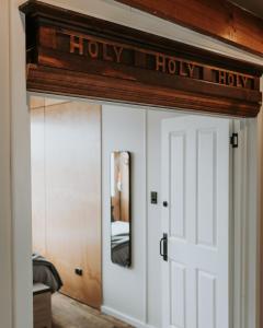 a door into a bedroom with a sign that reads holy house at The Rectory Zeehan in Zeehan +15 photos