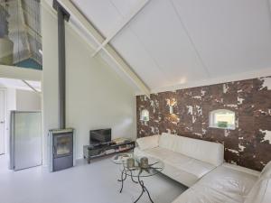 a living room with a white couch and a fireplace at Design Lodge Twente in Haaksbergen