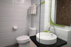 a white bathroom with a toilet and a sink at DK Belstar Hotel Belitung in Tanjungpandan +7 photos