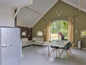 a living room with a refrigerator and a table at Design Lodge Twente in Haaksbergen