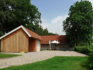 a barn with a table and a tent in a yard at Design Lodge Twente in Haaksbergen