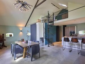 a dining room with a staircase and a table and chairs at The Green Wellness Cabin in Haaksbergen