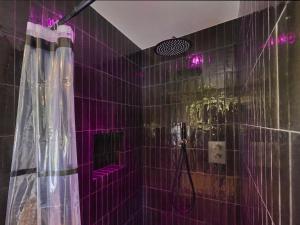 a purple tiled bathroom with a shower with purple lights at The Green Wellness Cabin in Haaksbergen +27 photos