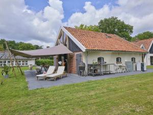 a patio with a table and chairs and a building at The Green Wellness Cabin in Haaksbergen