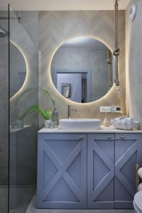 a bathroom with a blue vanity and a mirror at Apartament Aqua Przystań 80 - Rumia Novum, przy AQUAPARKREDA, z balkonem i bezpłatnym parkingiem in Rumia +35 photos