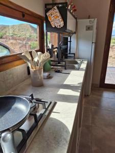 a kitchen with a stove and a counter top at Cabaña los amarillos in Huacalera