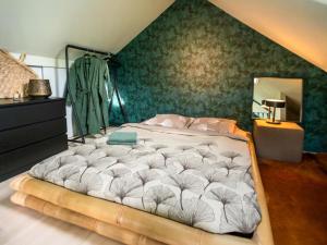 a large bed in a bedroom with a green wall at The Green Wellness Cabin in Haaksbergen