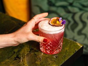 a hand holding a drink with a flower on it at Pullman Paris Centre - Bercy in Paris