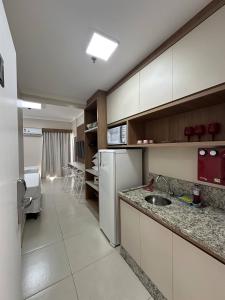 a kitchen with a white refrigerator and a sink at Spazzio diRoma com acesso ao Acqua Park in Caldas Novas