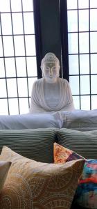 a statue sitting on top of a bed with pillows at Zen Retreat-Jacuzzi, kitchenette, Walk to fun in Reno