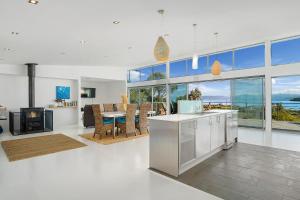 a kitchen and living room with a view of the ocean at Bruny Island Escapes and Hotel Bruny in Alonnah