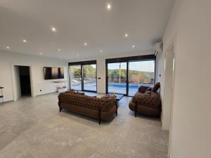 a living room with two leather couches and a television at Vila SOL DEL MAR in Utjeha
