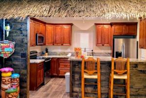 a kitchen with wooden cabinets and a bar with chairs at Tropical Spa Studio, Jacuzzi, Kitchen, Sparks in Sparks