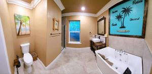 a bathroom with a tub and a toilet and a sink at Tropical Spa Studio, Jacuzzi, Kitchen, Sparks in Sparks +23 photos