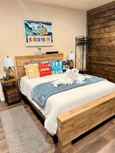 a bedroom with a large bed with a wooden wall at Tropical Spa Studio, Jacuzzi, Kitchen, Sparks in Sparks