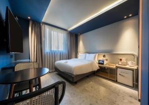 a hotel room with a bed and a table at 부산 대연동 뮤트호텔 in Kwangan-dong