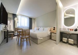 a hotel room with a bed and a table and chairs at 부산 대연동 뮤트호텔 in Kwangan-dong