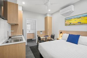 a hotel room with a bed and a sink at Avenue WEST Studio Units in Toowoomba
