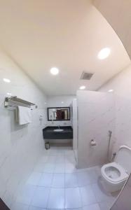 a white bathroom with a toilet and a sink at فيوبارك 2للشقق المخدومة درجةاقتصادية in Al Ahsa