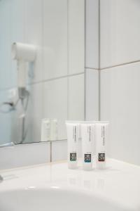 a group of three white toothbrushes in a bathroom at Avenue WEST Studio Units in Toowoomba +55 photos