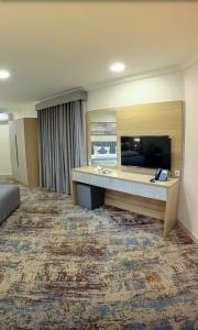 a hotel room with a flat screen tv and a bed at فيوبارك 2للشقق المخدومة درجةاقتصادية in Al Ahsa