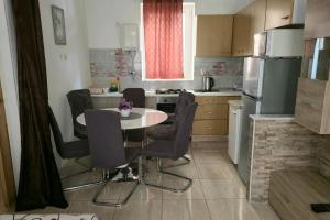 a kitchen with a table and chairs and a refrigerator at Seaside holiday house Drasnice, Makarska - 10359 in Drasnice