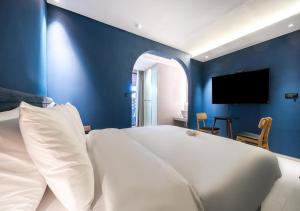 a bedroom with a white bed and a blue wall at 부산 대연동 뮤트호텔 in Kwangan-dong
