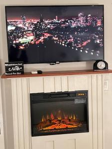 a fireplace with a flat screen tv and a television above it at Deco Studio Retreat with Fireplace, WiFi, Queen Bed in Reno