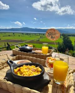 a table with a bowl of food and a glass of orange juice at Juncos Glamping in Fúquene